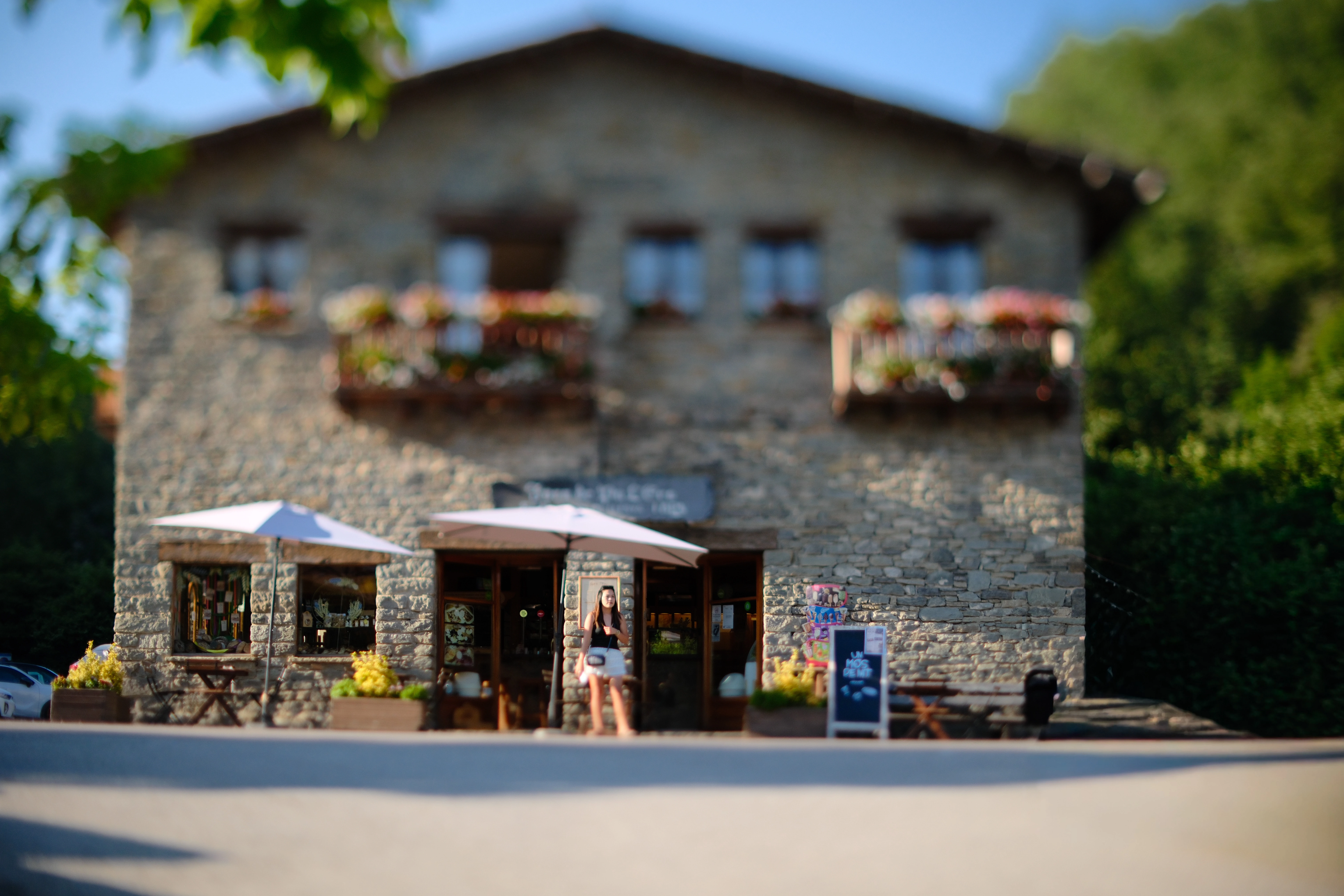 A stone shopfront and a standing figure isolated by selective focus